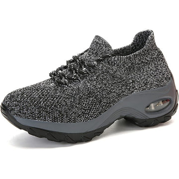 Gray athletic shoe with textured upper and black sole on a white background