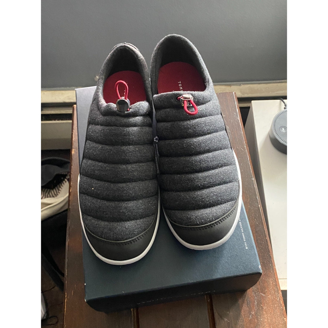 Gray quilted shoes on a box with a red interior