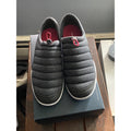 Gray quilted shoes on a box with a red interior
