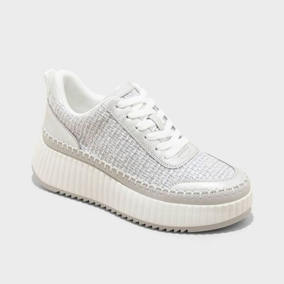 White sneaker with textured side panel on a light gray background