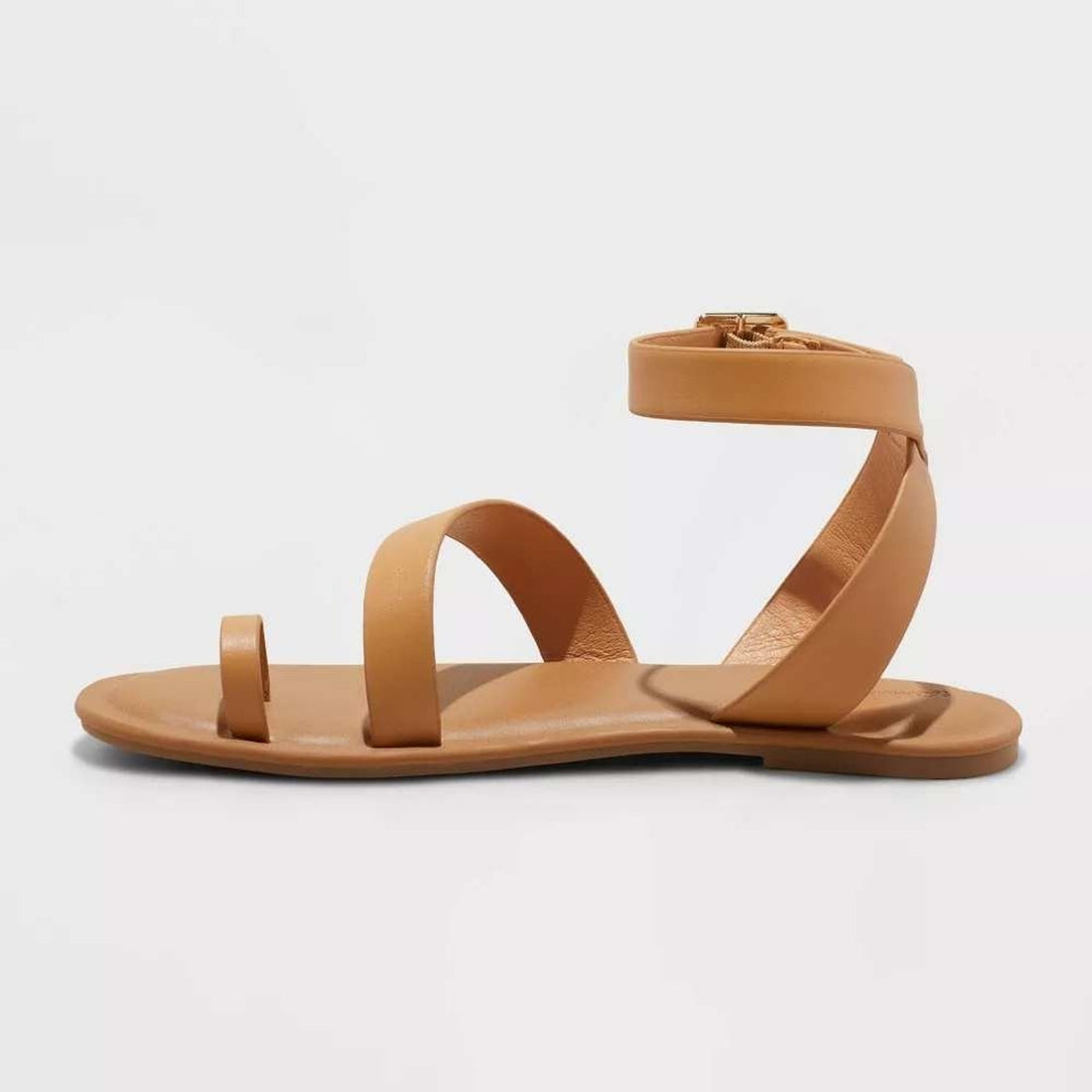 Tan sandal with criss-cross straps on a white background