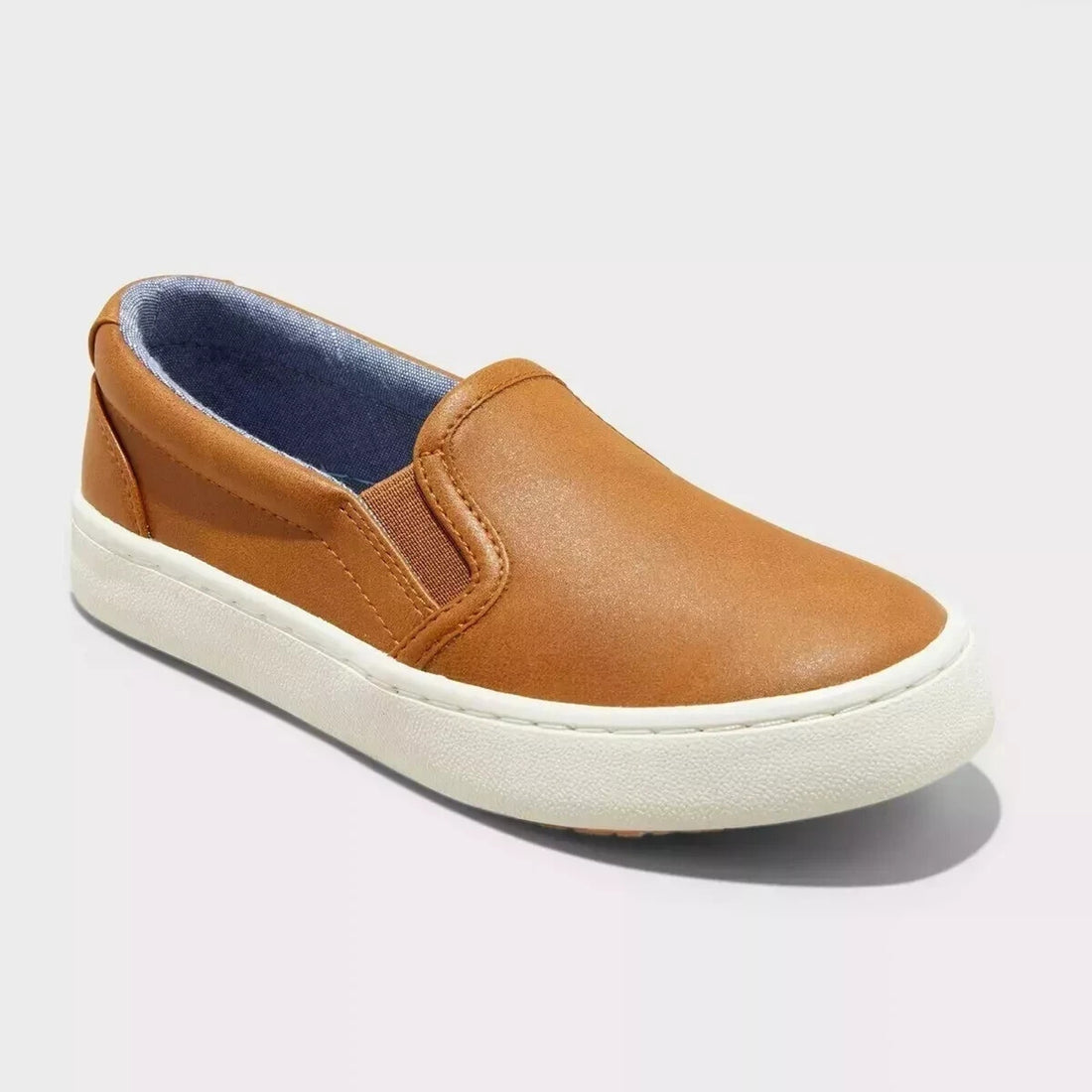Brown slip-on shoe with white sole on a light gray background