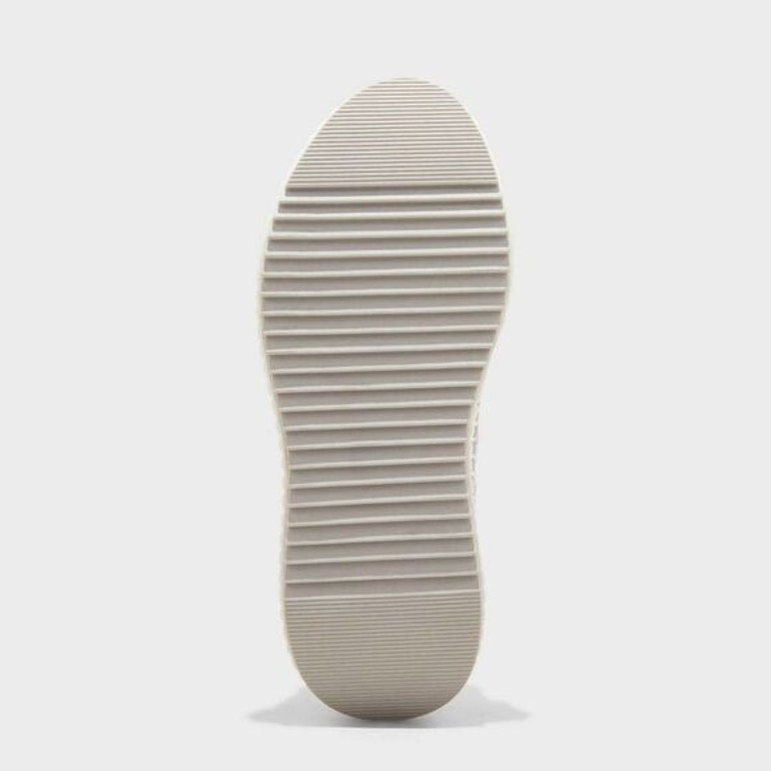 White sneaker with textured side panel on a light gray background