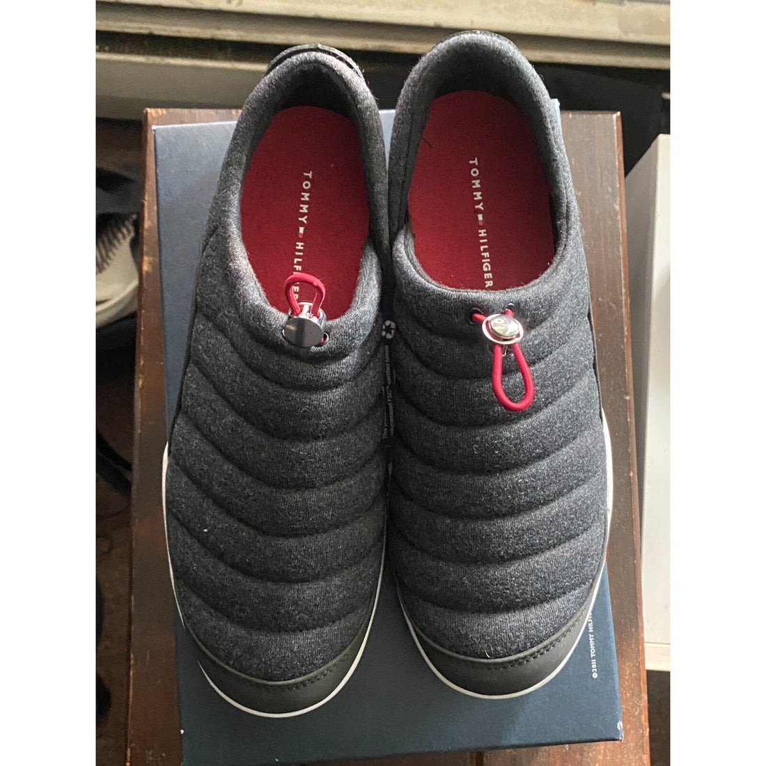 Gray quilted shoes on a box with a red interior