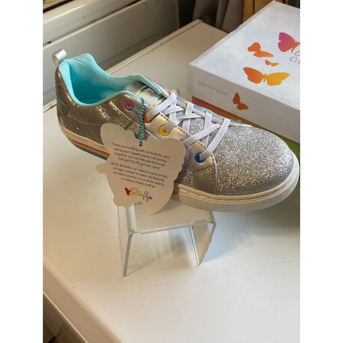 Silver glitter sneakers with colorful accents on a white background