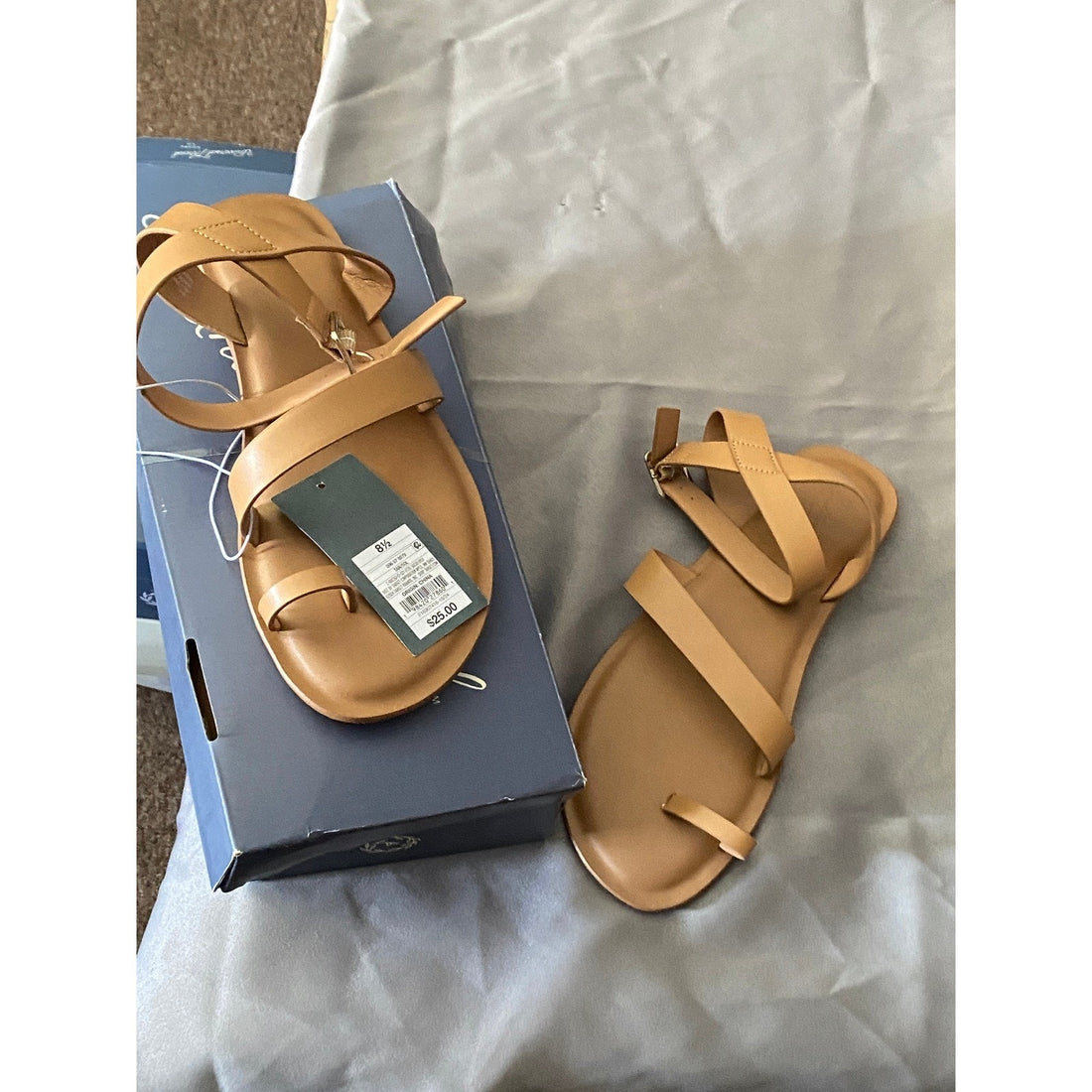 Tan sandal with criss-cross straps on a white background